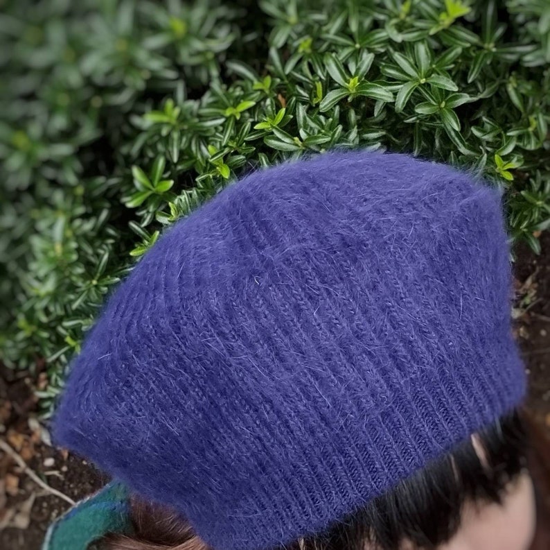 May include: A soft, blue, fuzzy beret with a ribbed texture.