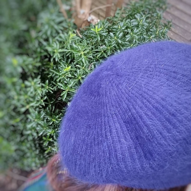 May include: A soft, fuzzy blue beret hat. The hat is made of a thick, textured yarn.