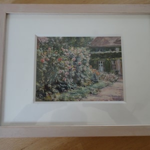Liten bild: Vykort med motiv av målaren Max Liebermann, "Rosenträdgård vid huset vid Wannsee". Bakom glas, i passepartout, i rosa ram.