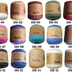 May include: A collection of raffia yarn balls in various colors, including white, beige, burgundy, green, pink, purple, teal, blue, gray, black, and tan. Each ball has a brown label with the text "fibra natura Raffia" and a product code.