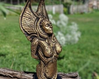 May include: A gold-colored statue of a woman with wings. The statue is detailed with intricate patterns and is standing on a black base.
