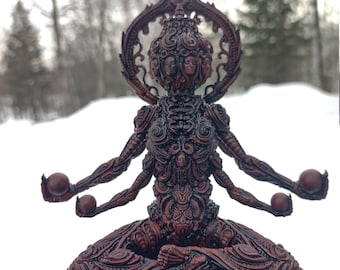 May include: A detailed, red, resin sculpture of a multi-armed deity sitting in a meditative pose. The deity has multiple faces and is adorned with intricate carvings.