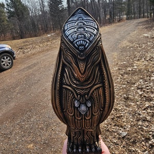 May include: A detailed, intricately carved, gold-coloured owl sculpture with silver accents. The owl is standing on a pair of feet with claws.
