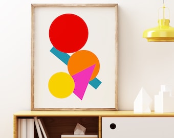 May include: A framed print with a geometric design featuring a red, orange, yellow, pink, and blue abstract design. The print is hanging above a wooden cabinet with a white drawer.
