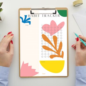 May include: A white habit tracker with a floral design. The tracker has a section for tasks and a section for notes. The floral design is in shades of pink, orange, yellow, and green.