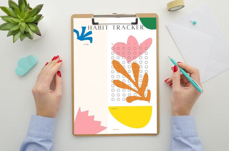 May include: A white habit tracker with a floral design. The tracker has a section for tasks and a section for notes. The floral design is in shades of pink, orange, yellow, and green.