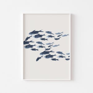 Peut inclure: Une peinture à l'aquarelle d'un banc de poissons bleus nageant sur un fond gris clair. Les poissons sont tous orientés dans la même direction et nagent en formation serrée.
