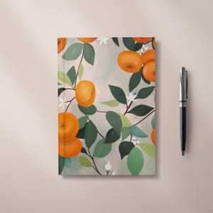 May include: A notebook cover with a repeating pattern of orange citrus fruit and white flowers on a light grey background.
