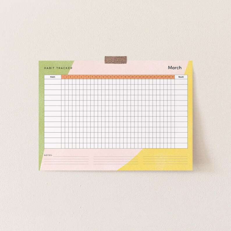 Peut inclure: Un suivi d'habitudes color&eacute; pour le mois de mars, avec une grille pour le suivi quotidien. Le design comprend un sch&eacute;ma de couleurs vert, rose et jaune avec les mots "Habit Tracker" et "March" imprim&eacute;s en haut. Le tracker est fix&eacute; avec un morceau de ruban adh&eacute;sif.