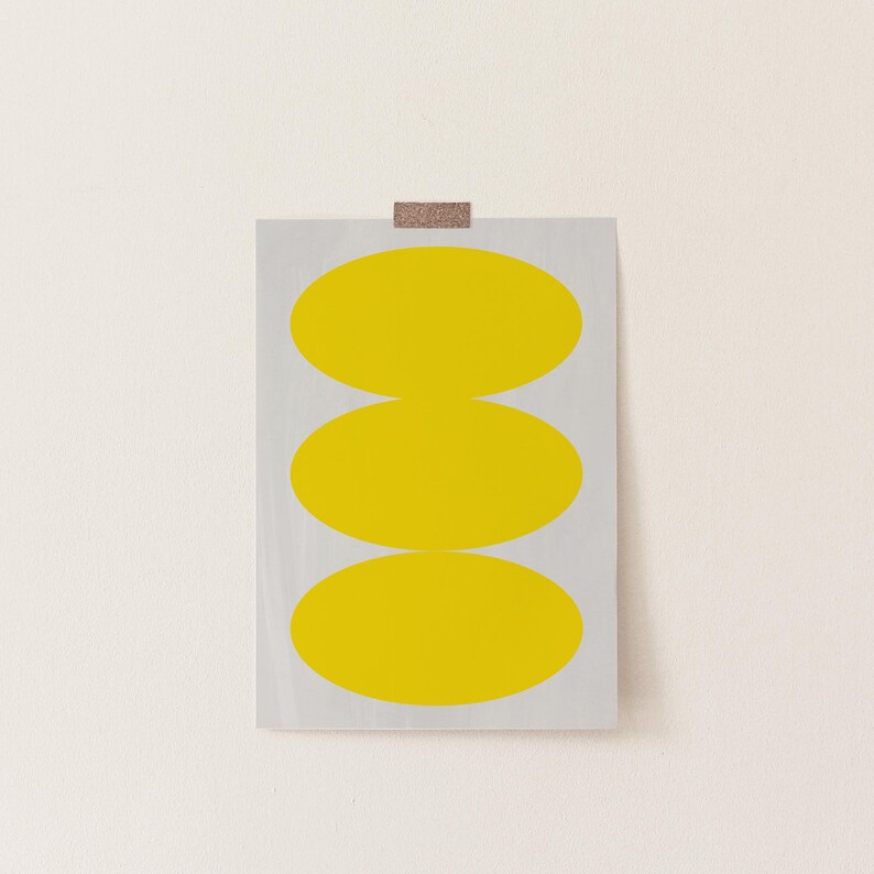 May include: A print with three stacked yellow ovals on a white background.