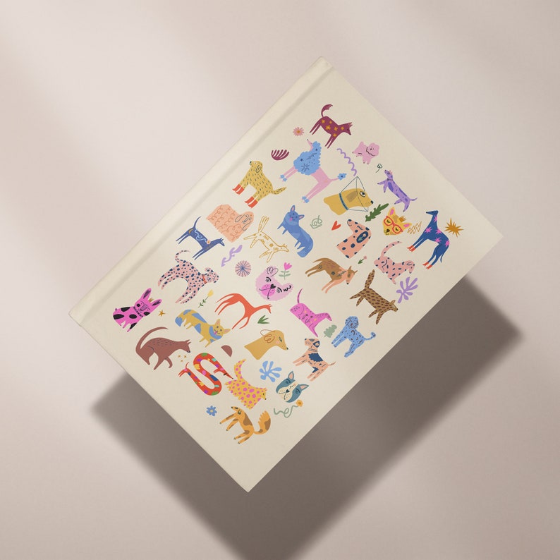 May include: A white notebook cover with a colorful illustration of various dogs in different poses and patterns. The dogs are depicted in a playful and whimsical style, with bright colors and bold outlines.