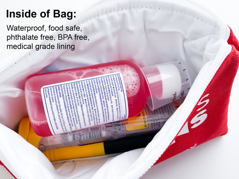 Op de afbeelding: Een rode ritszak met het woord "55" erop gedrukt. De zak is open en bevat een roze fles met een witte dop, een gele marker en andere items. De zak is gelabeld met "Inside of Bag: Waterproof, food safe, phthalate free, BPA free, medical grade lining."