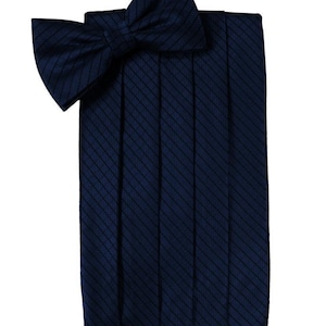 Op de afbeelding: Een donkerblauwe strik met een diagonaal gestreept patroon. De strik is gemaakt van een satijnachtig materiaal en is geplooid voor een formele look.