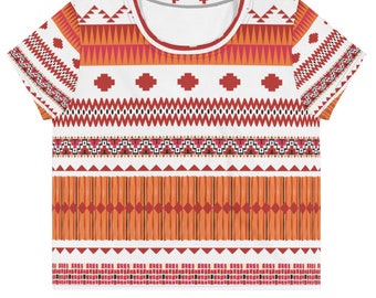 May include: A white cropped t-shirt with a geometric pattern in shades of orange, red, and black. The pattern is reminiscent of Native American art.