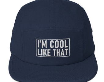 May include: A navy blue 5-panel cap with a white embroidered box that says "I'M COOL LIKE THAT".