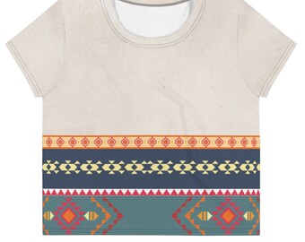 May include: A white cropped t-shirt with a geometric pattern in shades of blue, red, orange, and yellow. The pattern is a repeating design of squares, triangles, and diamonds.