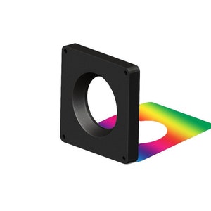 May include: A black square-shaped light diffuser with a round opening in the center. The diffuser is casting a rainbow-colored shadow on a white surface.