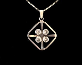 May include: A silver pendant necklace with a square-shaped design featuring four clear gemstones set in a geometric pattern.