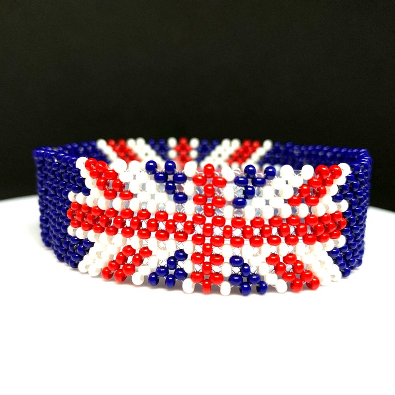 May include: A beaded bracelet with a red, white, and blue design that resembles the Union Jack flag.