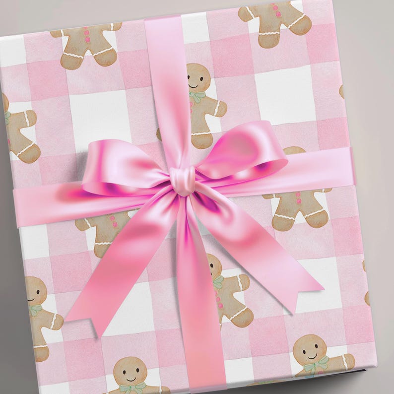 Peut inclure: Un coffret cadeau emball&eacute; avec un motif vichy rose et des bonhommes en pain d'&eacute;pices. Un grand ruban de satin rose est nou&eacute; en n&oelig;ud. Le papier d'emballage est id&eacute;al pour No&euml;l ou une baby shower. La bo&icirc;te est de forme carr&eacute;e.