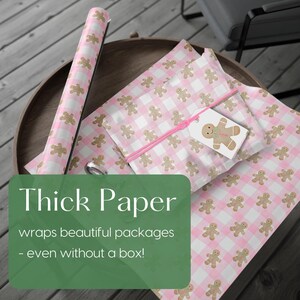 Peut inclure: Papier d'emballage &agrave; carreaux roses et blancs avec un motif de bonhomme en pain d'&eacute;pices. Un rouleau de papier et des paquets emball&eacute;s sont pr&eacute;sent&eacute;s. Une &eacute;tiquette cadeau avec un bonhomme en pain d'&eacute;pices est attach&eacute;e &agrave; un paquet avec de la ficelle rose. Le texte "Thick Paper" est visible.