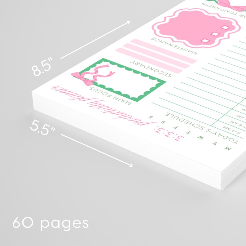 May include: A white productivity planner with pink and green accents. The planner is 8.5 inches by 5.5 inches and has 60 pages. Features include sections for main focus, secondary tasks, and a daily schedule.