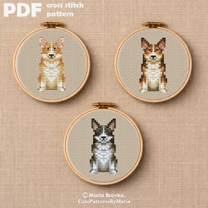 May include: Three cross-stitch patterns of dogs in embroidery hoops. The top left features a corgi in shades of orange, white, and tan. The top right shows a brown and white dog. The bottom shows a black and white dog. The text "PDF cross stitch pattern" is at the top.