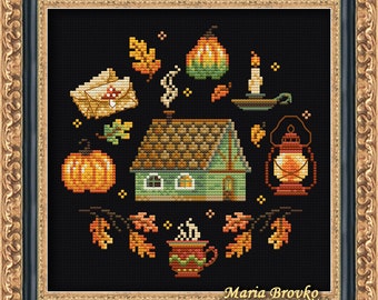 Può includere: Uno schema di ricamo a punto croce che presenta un accogliente cottage con camino, zucche, una lanterna, una tazza di tè e foglie autunnali su uno sfondo nero. Il testo "Maria Brovko (CutePatternsByMaria)" è nella parte inferiore del disegno.