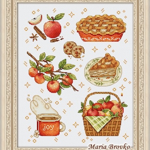 Può includere: Uno schema di ricamo a punto croce con una collezione di oggetti a tema mela, tra cui una torta, mele, un cesto di mele, una tazza di tè e biscotti. Lo schema è stato progettato da Maria Brovko e include il testo "joy" sulla tazza di tè.