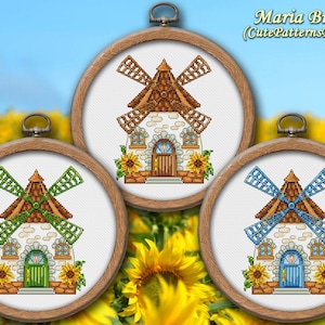 May include: Three framed cross-stitch embroidery designs of a stone windmill with a brown roof and sunflowers. The windmills have different colored blades: green, blue, and yellow.