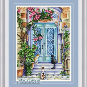 May include: Cross-stitch pattern featuring a blue door with intricate designs, surrounded by lush greenery and pink flowers. Three cats are sitting on the steps leading up to the door. The pattern is titled "Maria Brovko (CutePatternsByMaria)".