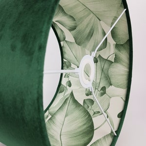 May include: A green velvet lampshade with a white lining featuring a green leaf pattern.