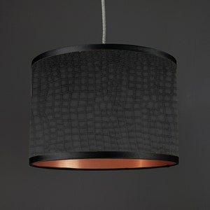 May include: Black pendant light shade with a crocodile-embossed fabric exterior and a copper-colored inner lining.