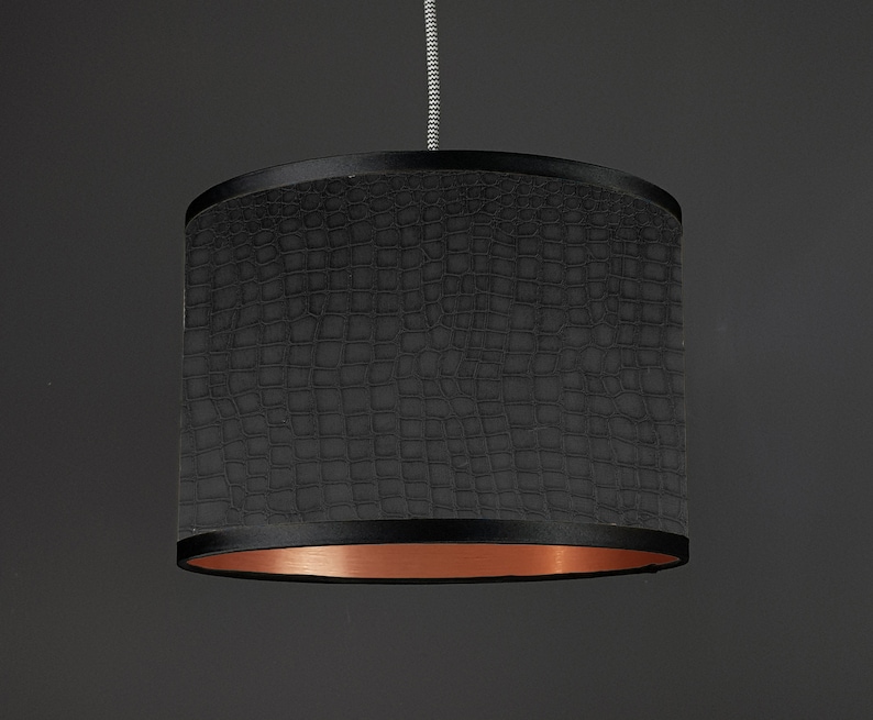 May include: Black pendant light shade with a crocodile-embossed fabric exterior and a copper-colored inner lining.