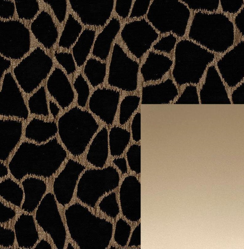 May include: Black fabric with a gold animal print pattern. The fabric is next to a solid gold colored surface.