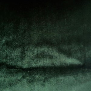 May include: A dark green textured fabric background with a subtle gradient from dark to light.