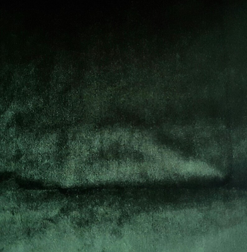 May include: A dark green textured fabric background with a subtle gradient from dark to light.