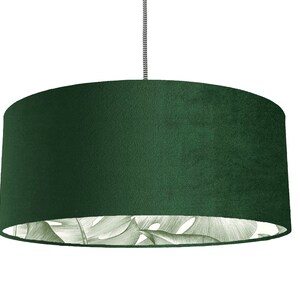 May include: A dark green velvet lampshade with a white and green tropical leaf pattern on the inside.