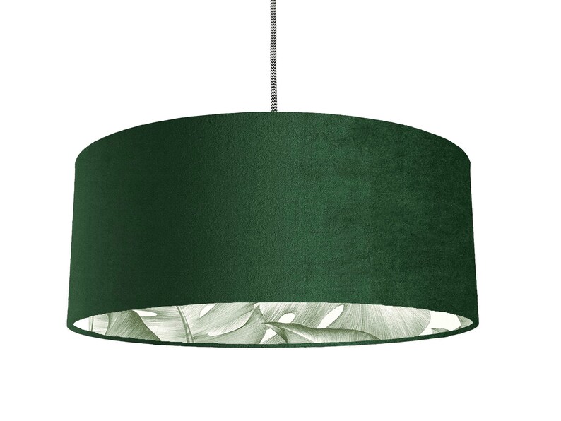 May include: A dark green velvet lampshade with a white and green tropical leaf pattern on the inside.