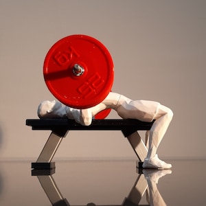 Peut inclure: Une figurine blanche d'une personne soulevant une plaque de poids rouge sur un banc de musculation noir.