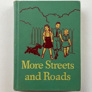 May include: A green book with the title "More Streets and Roads" on the cover. The cover features an illustration of three children walking down a street with a dog.