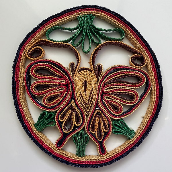 retro 1970's 8" woven rattan trivet with butterfly in fuchsia indigo tan & green  vintage straw pot holder hot pad or wall hanging