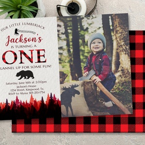May include: A red and black plaid invitation for a first birthday party. The invitation features a photo of a young boy holding an axe, a silhouette of a moose, and a bear. The text on the invitation reads "Our Little Lumberjack Jackson's is turning one. Flannel up for some fun!"  Saturday, June 16th at 2:00pm Jackson's House 1234 Street, Kingwood, Tx RSVP to Alyssa 365-253-1754