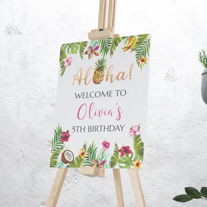 Peut inclure: Panneau de bienvenue pour le 5&egrave;me anniversaire d'Olivia avec des feuilles tropicales, des fleurs, un ananas et des bananes. Le panneau est sur un chevalet en bois.
