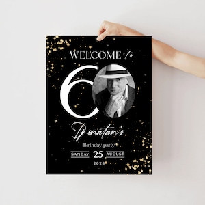 以下が含まれることがあります： 黒と金の誕生日パーティーのウェルカムサイン。「Welcome to 60 Donatan's Birthday party」と書かれており、帽子をかぶった男性の白黒写真が添えられています。日付は2023年8月25日です。