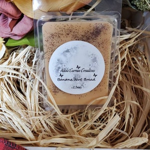 May include: A 2.5 oz wax melt in a clear plastic container. The wax melt is a light brown color and has a speckled appearance. The label on the wax melt says "Nikki Curran Creations Banana Nut Bread".