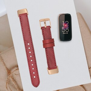 May include: Two red leather watch bands with gold hardware. The bands are shown on a white surface with a black smartwatch displaying the time 12:58 and the date Wed 28.