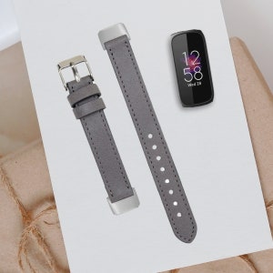 May include: Two gray leather watch bands with silver buckles. The bands are designed for a smart watch. The watch face displays the time as 12:58 and the date as Wed 28.