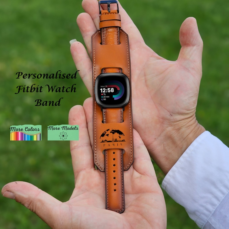 May include: A brown leather watch band with a personalized "PARIS" design. The band is designed to fit a Fitbit watch. The watch face shows the time as 12:58.