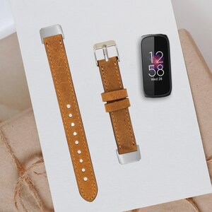 May include: Two brown leather watch bands with silver buckles. The watch bands are for a smart watch. The watch face shows the time as 12:58 and the day as Wed 28.